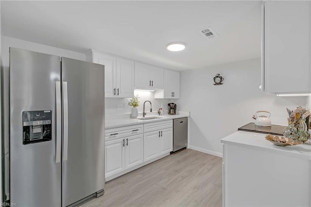 392 Deputy Ln Unit D, Newport News, VA 23608 - kitchen featuring stainless steel appliances, a sink, light countertops, white cabinetry, and light wood-style floors