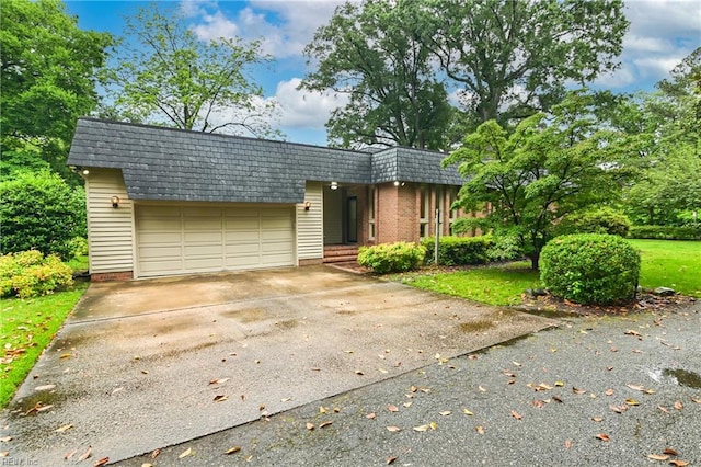5209 Studeley Ave, Norfolk, VA 23508 - view of front facade with a garage, driveway, mansard roof, brick siding, and a shingled roof