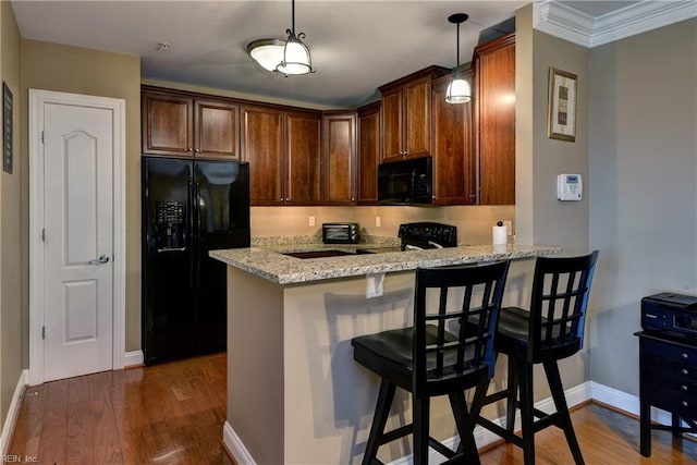 5413 Foundation St, Williamsburg, VA 23188 - kitchen with black appliances, baseboards, a peninsula, light stone countertops, and ornamental molding