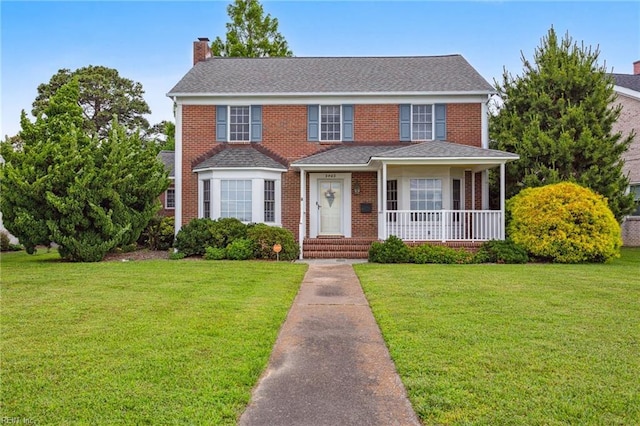 3403 Chesapeake Ave, Hampton, VA 23661 - view of front facade featuring a chimney, a front lawn, brick siding, and a porch
