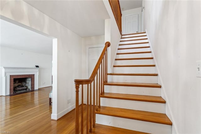 3403 Chesapeake Ave, Hampton, VA 23661 - staircase featuring wood finished floors, baseboards, and a brick fireplace