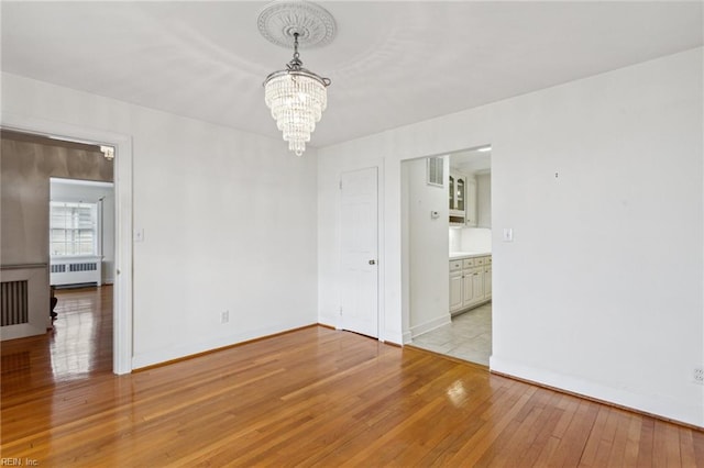 3403 Chesapeake Ave, Hampton, VA 23661 - unfurnished room featuring radiator, a chandelier, light wood finished floors, and baseboards