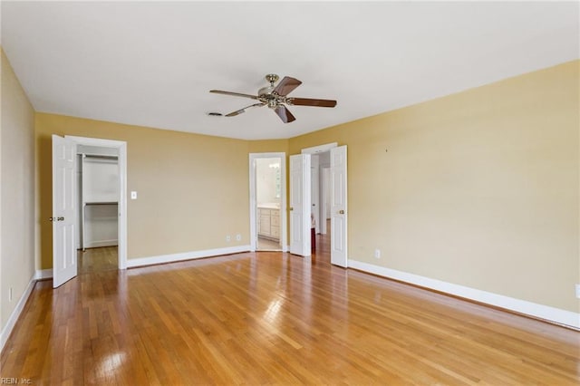 3403 Chesapeake Ave, Hampton, VA 23661 - unfurnished bedroom featuring a walk in closet, light wood-style floors, baseboards, a closet, and a ceiling fan