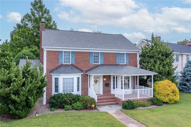 3403 Chesapeake Ave, Hampton, VA 23661 - view of front of house with covered porch, a chimney, a front yard, roof with shingles, and brick siding
