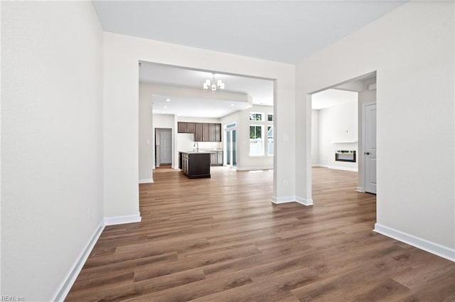 2300 Venture Way Unit B, Suffolk, VA 23434 - unfurnished living room featuring a chandelier, dark wood-type flooring, baseboards, and a sink