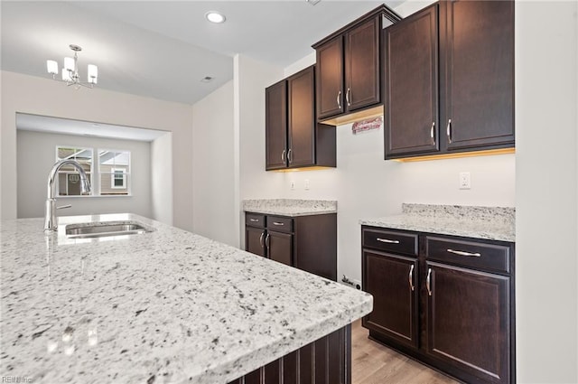 2300 Venture Way Unit B, Suffolk, VA 23434 - kitchen with a sink, dark brown cabinetry, light wood finished floors, light stone countertops, and recessed lighting