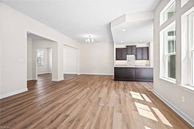 2300 Venture Way Unit B, Suffolk, VA 23434 - unfurnished living room with a sink, a chandelier, light wood-style flooring, and baseboards