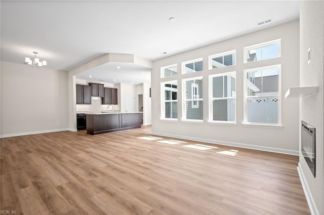 2300 Venture Way Unit B, Suffolk, VA 23434 - unfurnished living room featuring a chandelier, baseboards, light wood-type flooring, and plenty of natural light