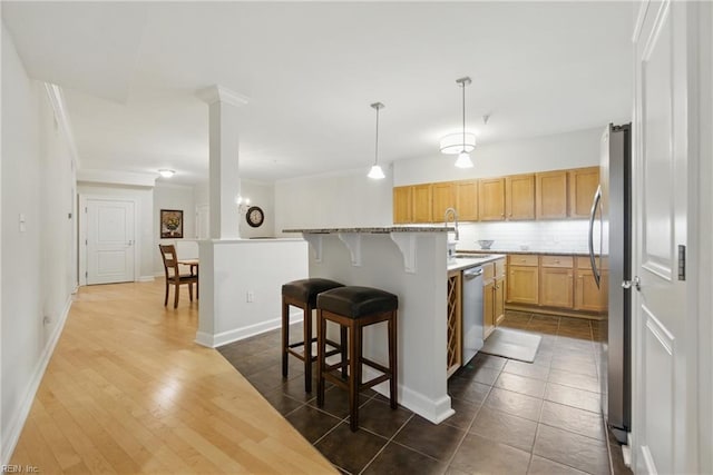 4250 Granby St Unit 109, Norfolk, VA 23504 - kitchen with stainless steel appliances, a breakfast bar, decorative backsplash, ornamental molding, and an island with sink