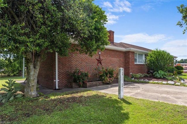 1232 Typo Ave, Norfolk, VA 23502 - view of property exterior featuring a chimney, a lawn, and brick siding