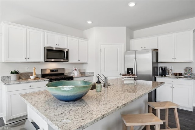 3031 Dalton Cir, Suffolk, VA 23435 - kitchen with appliances with stainless steel finishes, a breakfast bar area, white cabinets, light stone counters, and recessed lighting