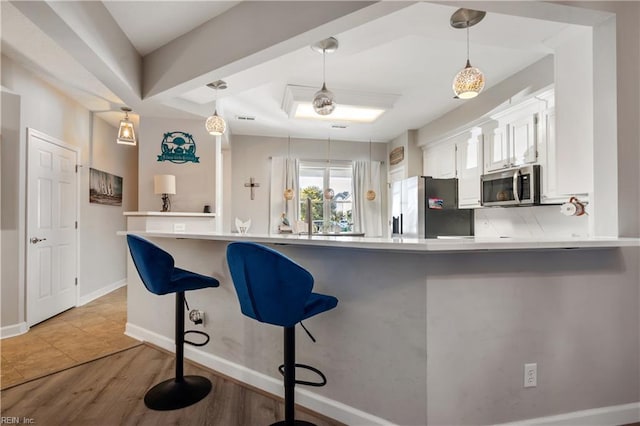 1031 High Dunes Quay Quay Unit 103, Hampton, VA 23664 - kitchen with appliances with stainless steel finishes, white cabinetry, light wood-style flooring, pendant lighting, and light countertops