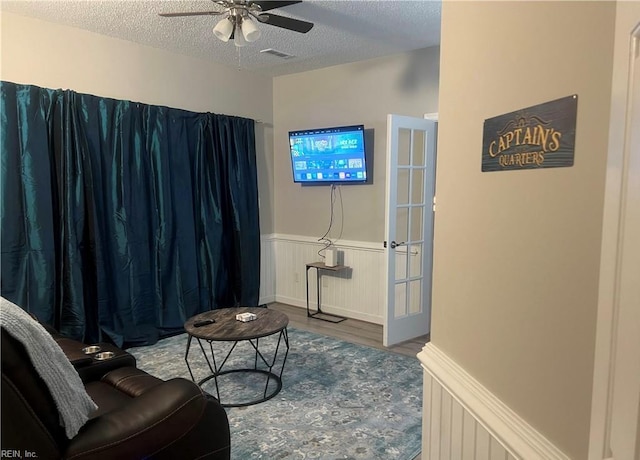 1031 High Dunes Quay Quay Unit 103, Hampton, VA 23664 - sitting room with wood finished floors, a wainscoted wall, a textured ceiling, and ceiling fan