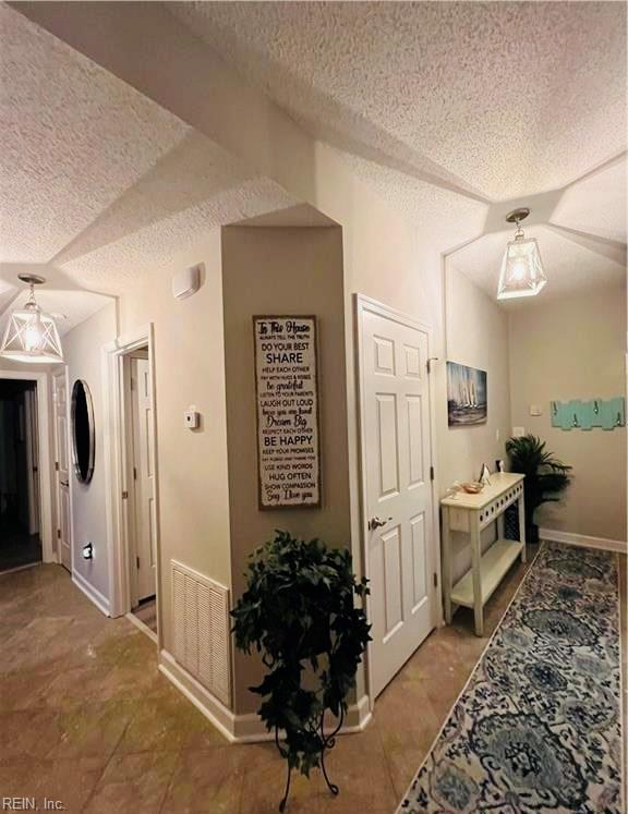 1031 High Dunes Quay Quay Unit 103, Hampton, VA 23664 - hall with a textured ceiling and baseboards