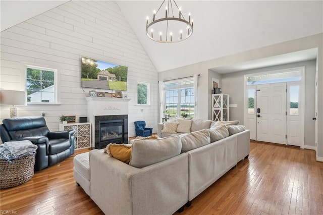 183 Belle Aire Dr, Hardyville, VA 23070 - living room with healthy amount of natural light, high vaulted ceiling, hardwood / wood-style flooring, a chandelier, and a glass covered fireplace