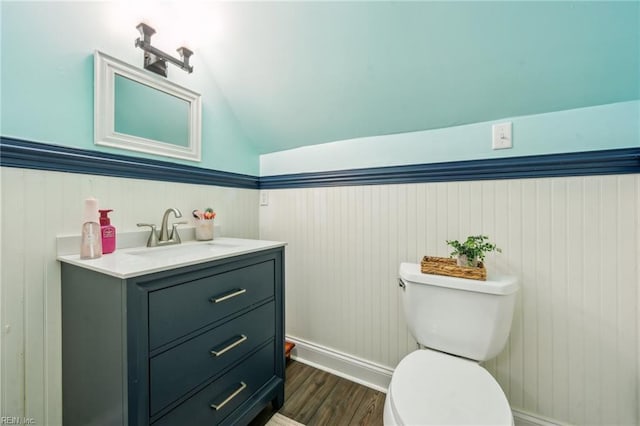 183 Belle Aire Dr, Hardyville, VA 23070 - bathroom with toilet, vaulted ceiling, vanity, wood finished floors, and a wainscoted wall