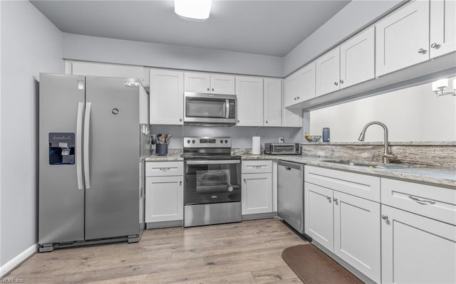 403 Joel Ct, Newport News, VA 23608 - kitchen featuring stainless steel appliances, a sink, white cabinets, light wood-type flooring, and light stone counters