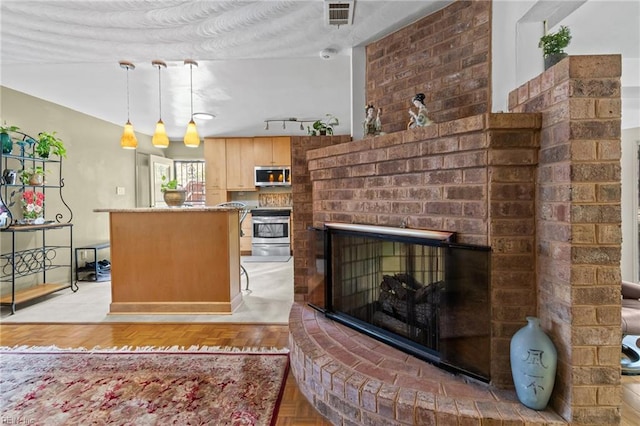 224 Iroquois Rd, Virginia Beach, VA 23462 - kitchen with stainless steel microwave, stove, a brick fireplace, pendant lighting, and light brown cabinetry
