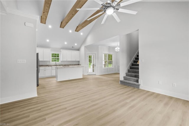 1064 Tulls Creek Rd, Moyock, NC 27958 - unfurnished living room with high vaulted ceiling, beam ceiling, stairs, a ceiling fan, and light wood-style floors