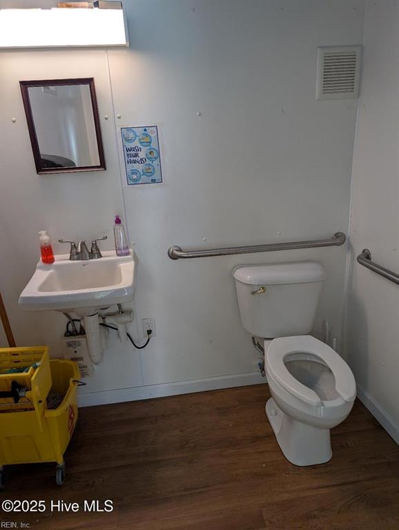 209 Main St, South Mills, NC 27976 - bathroom featuring wood finished floors, toilet, baseboards, and a sink
