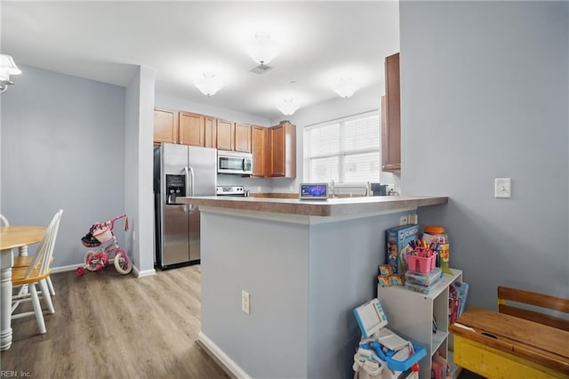 4316 Colindale Rd Unit 106, Chesapeake, VA 23321 - kitchen featuring appliances with stainless steel finishes, light wood-type flooring, a peninsula, and baseboards