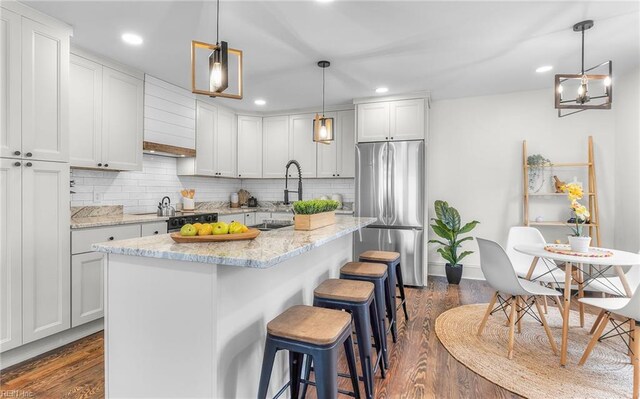 1006 Mayfield Ave, Chesapeake, VA 23324 - kitchen featuring freestanding refrigerator, dark wood finished floors, tasteful backsplash, a kitchen breakfast bar, and recessed lighting