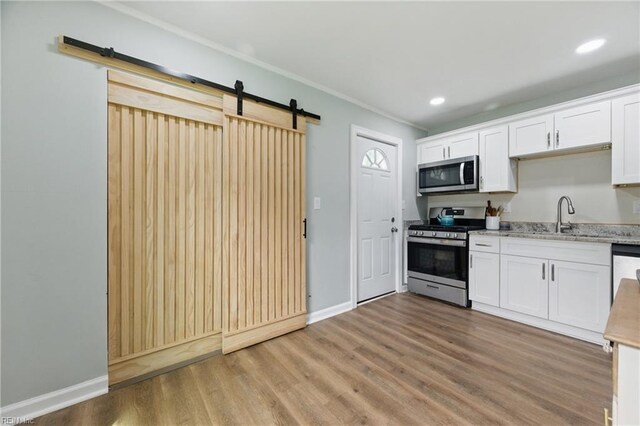 400 Cedar Dr, Hampton, VA 23669 - kitchen with stainless steel appliances, a barn door, a sink, white cabinets, and wood finished floors