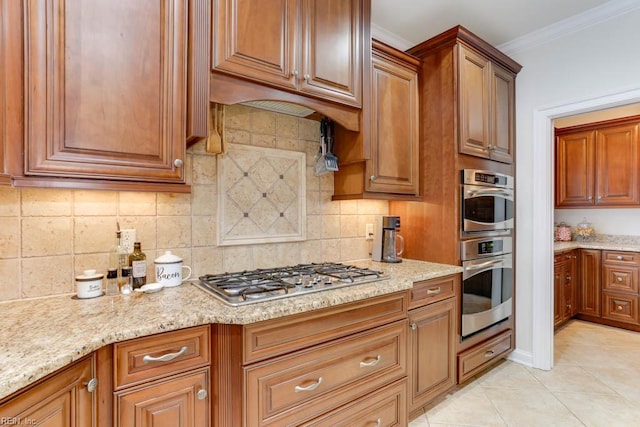 102 Ships Lndg, Carrollton, VA 23314 - kitchen featuring stainless steel gas cooktop, brown cabinets, light stone counters, and ornamental molding