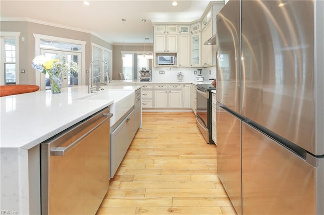 1920 Flintshire Dr, Chesapeake, VA 23323 - kitchen featuring stainless steel appliances, a sink, light wood-style floors, crown molding, and light countertops