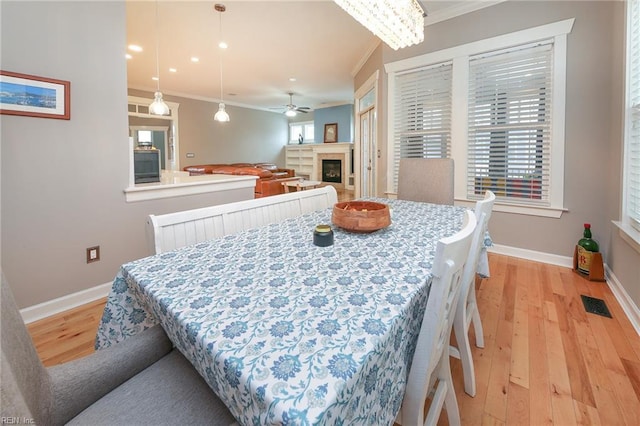 1920 Flintshire Dr, Chesapeake, VA 23323 - dining area with crown molding, light wood-style flooring, baseboards, a glass covered fireplace, and ceiling fan