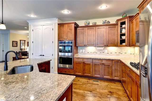 3907 Ethan Ln, Williamsburg, VA 23188 - kitchen featuring a sink, appliances with stainless steel finishes, brown cabinets, light wood finished floors, and recessed lighting