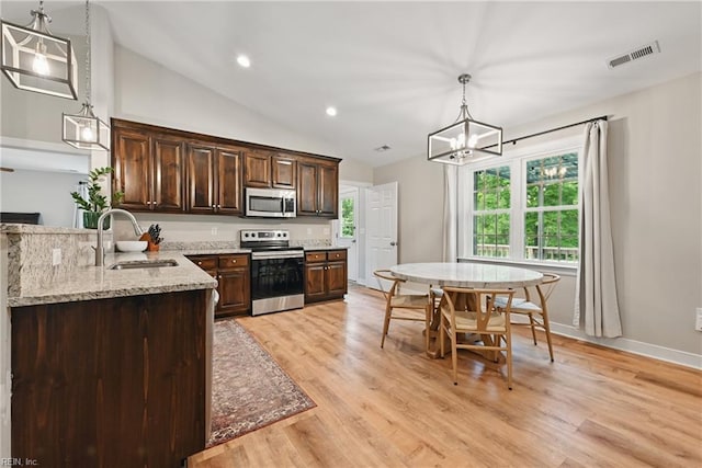320 Pamunkey Ridge Rd, King William, VA 23086 - kitchen featuring appliances with stainless steel finishes, a sink, dark brown cabinets, decorative light fixtures, and light stone counters