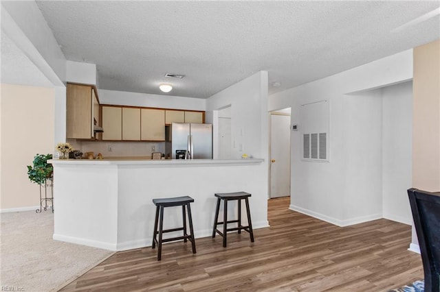 5113 Thatcher Way, Virginia Beach, VA 23456 - kitchen featuring stainless steel fridge, wood finished floors, a textured ceiling, baseboards, and a breakfast bar area