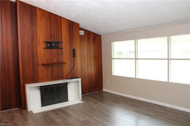 5857 Frament Ave, Norfolk, VA 23502 - unfurnished living room with baseboards, wood finished floors, a fireplace, and wooden walls