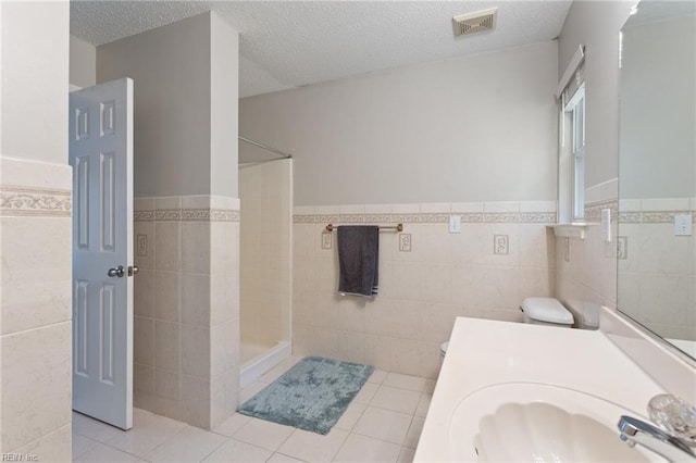 6218 Whaley Ct, Norfolk, VA 23502 - full bathroom with tile walls, walk in shower, wainscoting, tile patterned floors, and vanity