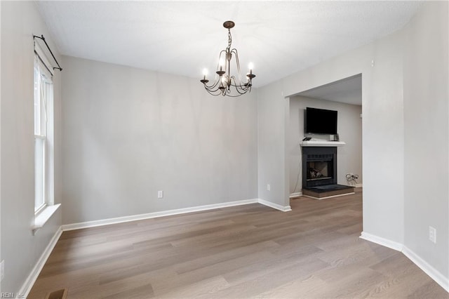 6218 Whaley Ct, Norfolk, VA 23502 - empty room featuring a chandelier, wood finished floors, baseboards, and a fireplace with raised hearth