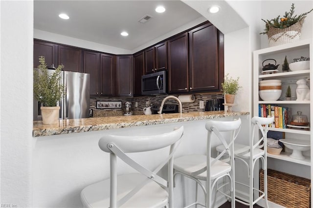 5516 Sadie Ln, Virginia Beach, VA 23462 - kitchen featuring stainless steel appliances, light stone countertops, dark brown cabinetry, backsplash, and recessed lighting