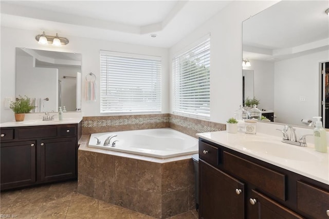 5516 Sadie Ln, Virginia Beach, VA 23462 - bathroom featuring a raised ceiling, a garden tub, two vanities, and tile patterned flooring