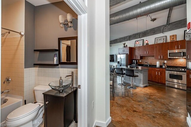 415 Saint Pauls Blvd Unit 309, Norfolk, VA 23510 - kitchen featuring stainless steel appliances, a sink, backsplash, a breakfast bar, and dark countertops