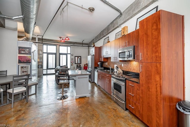 415 Saint Pauls Blvd Unit 309, Norfolk, VA 23510 - kitchen featuring stainless steel appliances, concrete floors, a sink, backsplash, and a breakfast bar area