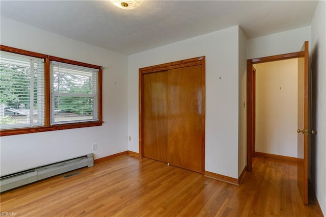 449 Martha Lee Dr, Hampton, VA 23666 - unfurnished bedroom featuring a baseboard heating unit, light wood finished floors, a closet, and baseboards