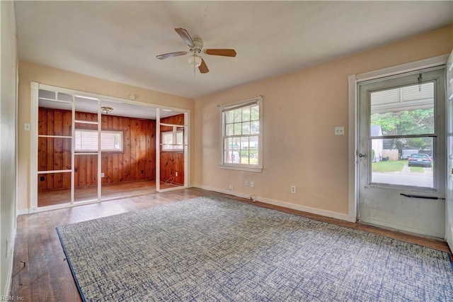 10 Dotson Dr, Hampton, VA 23669 - unfurnished bedroom featuring wood finished floors, baseboards, a ceiling fan, and wood walls