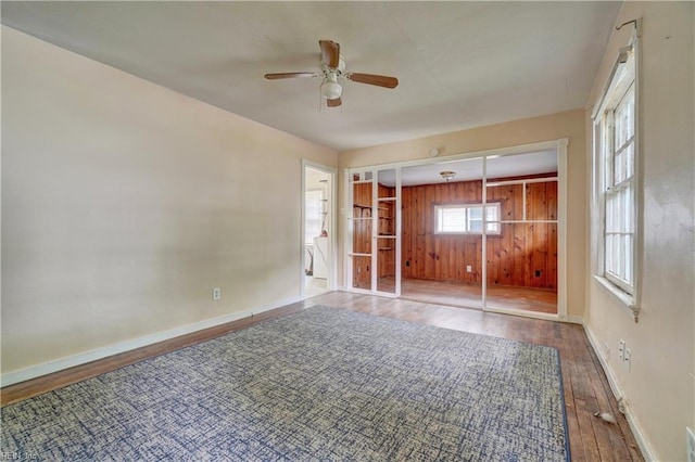 10 Dotson Dr, Hampton, VA 23669 - unfurnished bedroom featuring wood finished floors, baseboards, wooden walls, and a ceiling fan