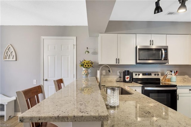 189 Shoal Crk, Williamsburg, VA 23185 - kitchen featuring stainless steel microwave, range with electric cooktop, a sink, a peninsula, and white cabinets