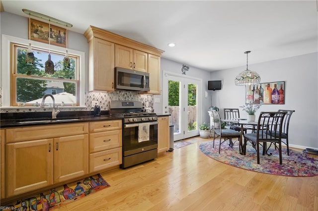 1 Hatteras Lndg, Hampton, VA 23669 - kitchen with appliances with stainless steel finishes, a sink, light wood-type flooring, dark countertops, and backsplash