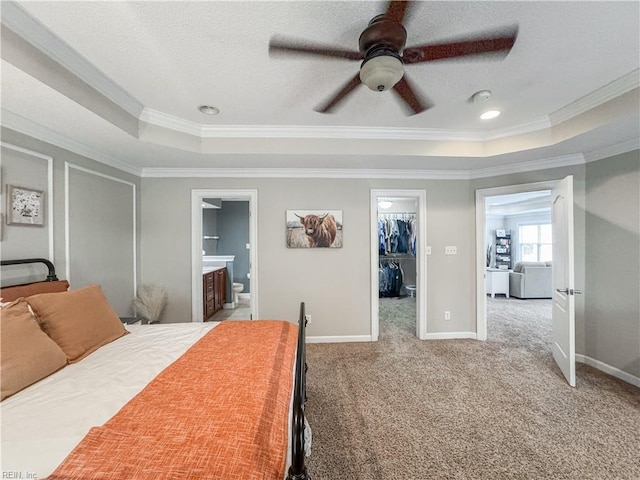 5541 Frog Pond Ln, Virginia Beach, VA 23455 - carpeted bedroom with a tray ceiling, crown molding, a walk in closet, baseboards, and ensuite bathroom