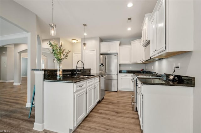 1120 Veranda Way, Chesapeake, VA 23320 - kitchen with a sink, stainless steel appliances, arched walkways, light wood-style floors, and white cabinets