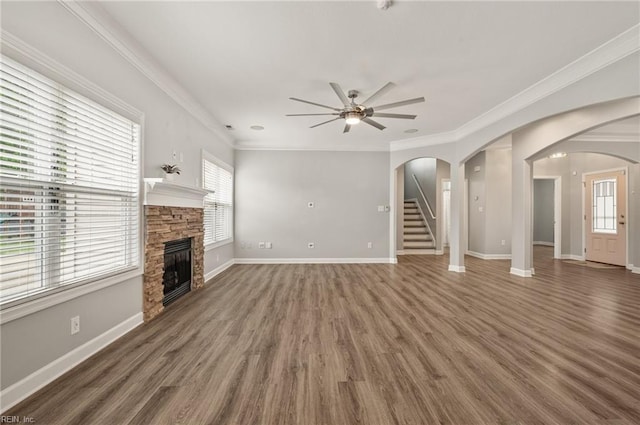 1120 Veranda Way, Chesapeake, VA 23320 - unfurnished living room featuring ceiling fan, a stone fireplace, healthy amount of natural light, arched walkways, and crown molding