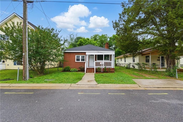 111 S Lloyd St, Suffolk, VA 23434 - view of front of property featuring covered porch, brick siding, and a chimney