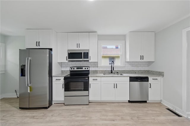 111 S Lloyd St, Suffolk, VA 23434 - kitchen featuring appliances with stainless steel finishes, a sink, backsplash, white cabinetry, and light stone counters
